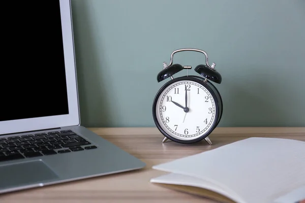 Laptop, clock and notebook on table — Stock Photo, Image