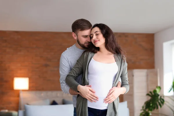 Portrét šťastného těhotného páru doma — Stock fotografie