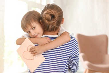 Sevimli küçük çocuk annesi evde sarılma tebrik kartı