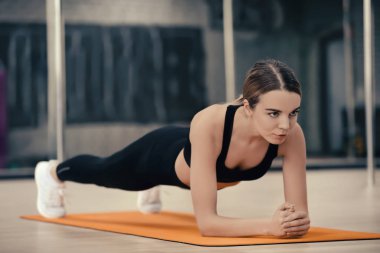 Modern spor salonunda eğitim gören genç bir kadın.