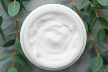 Gri arka plan, üstten görünüm üzerinde bitkisel özü ile krem kavanoz