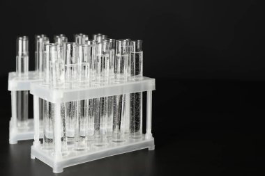 Siyah arka plan üzerinde test tüpleri ile stand