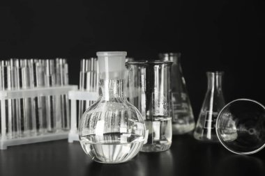 Test tüpleri ve şişe su siyah arka plan karşı masada ile