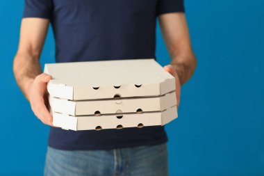 Teslimatçı renk arka plan üzerinde karton pizza kutuları ile