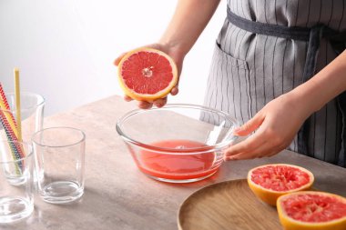 Kadın kase tablo üzerinde narenciye meyve sıkma