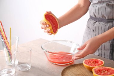 Kadın kase tablo üzerinde narenciye meyve sıkma