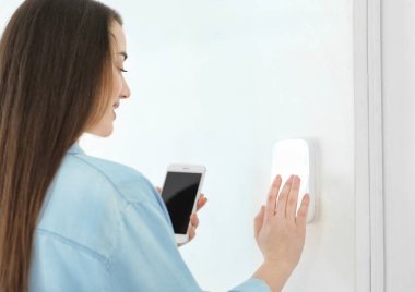 Telefon kapalı güvenlik sistemiyle olan kadın