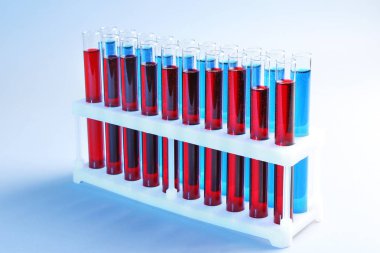 Test tüpleri tutucu renk arka plan üzerinde farklı sıvılar ile