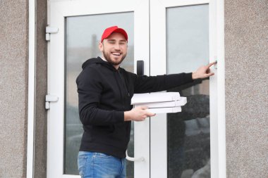 Karton pizza ile genç adam zil kapı zili açık havada kutuları. Gıda dağıtım hizmeti