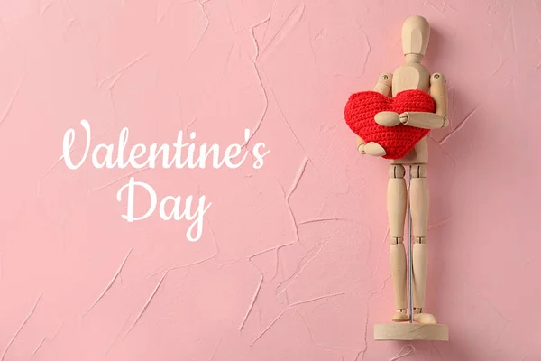 Small wooden mannequin with red heart on color background. Valentines Day celebration — Stock Photo, Image
