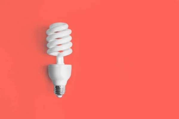 Modern light bulb on coral background — Stock Photo, Image