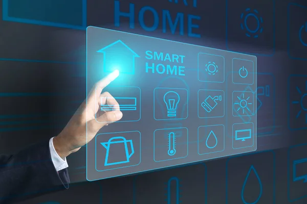 Businessman using futuristic interface of smart home automation on dark background — Stock Photo, Image