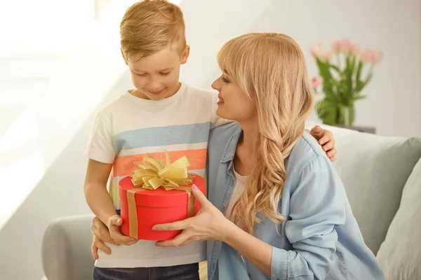 Portrait of cute little boy and his mother with gift box at home — Stock Photo, Image