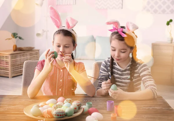 Aranyos kislány festmény tojás húsvéti asztalnál — Stock Fotó