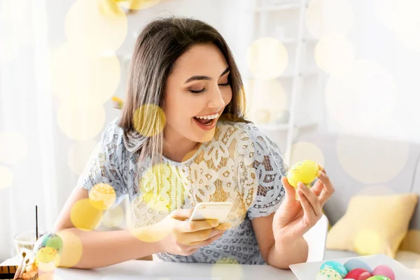 Mladá žena pořizování fotografii malovaná velikonoční vajíčka doma — Stock fotografie