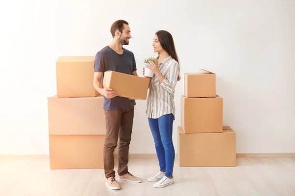 Casal jovem com caixas de papelão depois de se mudar para casa nova — Fotografia de Stock