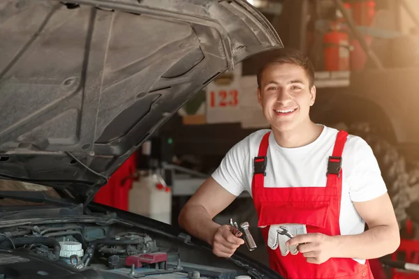 Young auto mechanic repairing car in service center — Stock Photo, Image