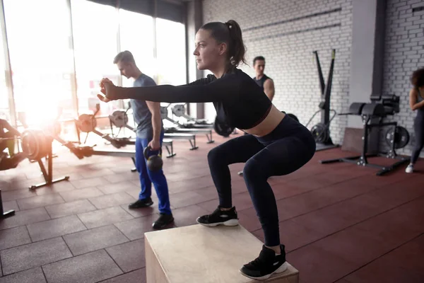 Sportiga kvinnan gör övningar i gym — Stockfoto