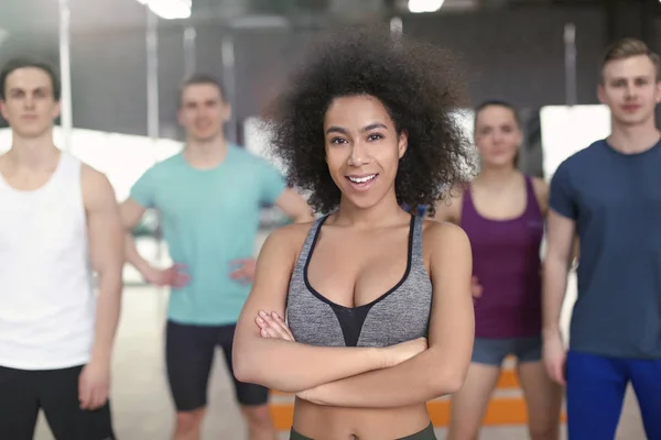 Mulher afro-americana esportiva com grupo de atletas em ginásio — Fotografia de Stock