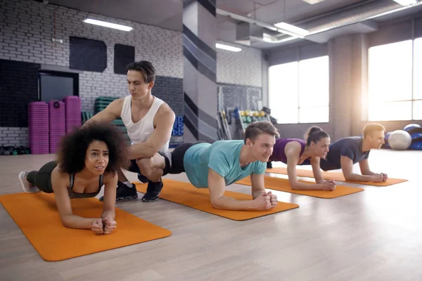 Jóvenes deportistas haciendo ejercicio en el gimnasio — Foto de Stock