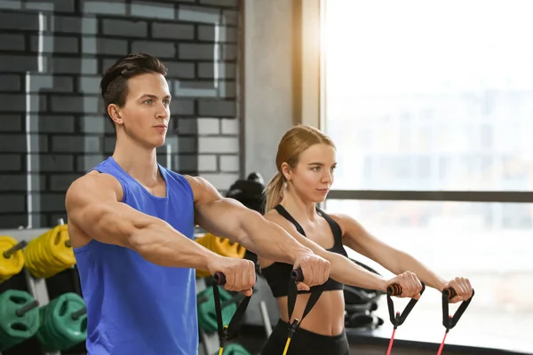 Jonge sportieve man en vrouw training in moderne sportschool — Stockfoto