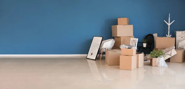 Cajas de cartón y artículos interiores preparados para mudarse a una nueva casa cerca de la pared de color —  Fotos de Stock