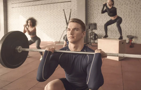 Atletisk man träning med skivstång i moderna gym — Stockfoto