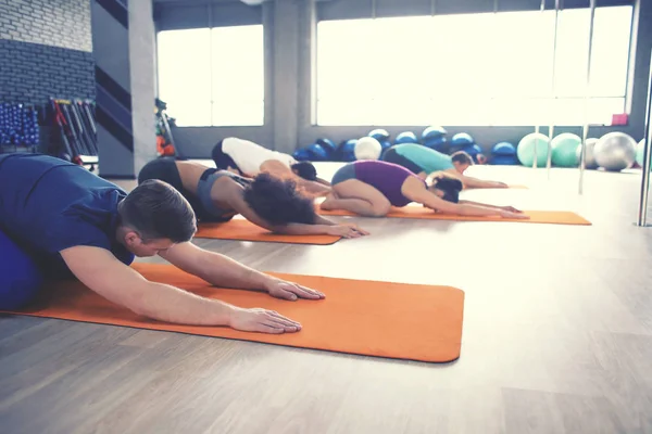 Tinerii fac yoga în sala de gimnastică — Fotografie, imagine de stoc