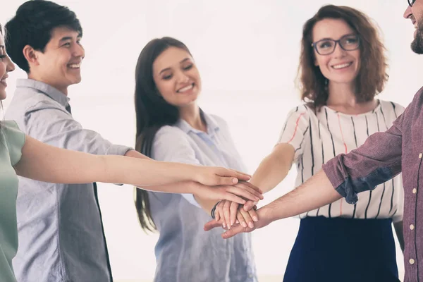 Reunión del equipo empresarial poniendo las manos juntas como símbolo de unidad sobre fondo claro — Foto de Stock