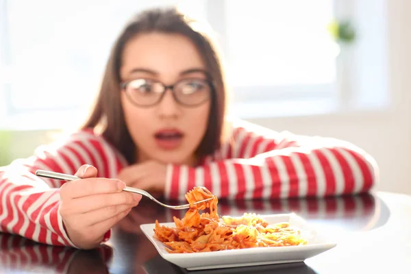 Mujer joven comiendo deliciosa pasta en la mesa, primer plano — Foto de Stock