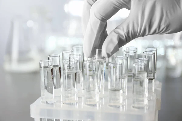 Laboratory worker taking test tube with water, closeup