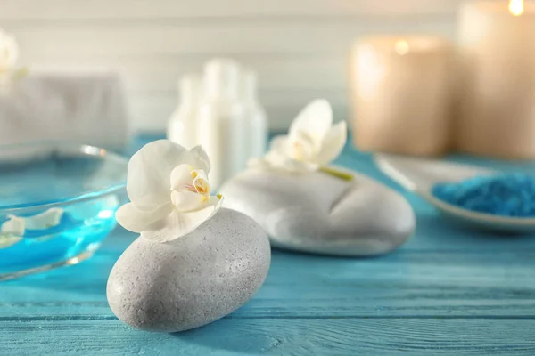Spa stone with beautiful flower on wooden table — Stock Photo, Image