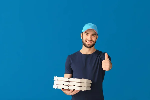 Delivery man with cardboard pizza boxes on color background — Stock Photo, Image