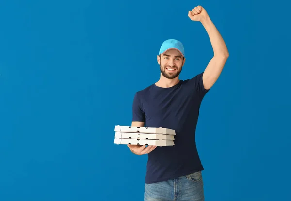Доставщик с картонными коробками пиццы на цветном фоне — стоковое фото