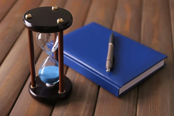 Eleganta hourglass och anteckningsbok på bordet. Time management koncept — Stockfoto