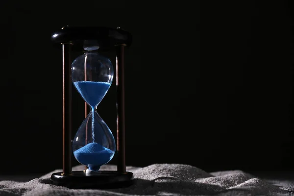 Reloj de arena de cristal sobre fondo oscuro. Concepto de gestión del tiempo —  Fotos de Stock