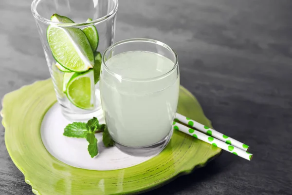 Jugo fresco en vaso y cítricos en rodajas sobre fondo gris — Foto de Stock