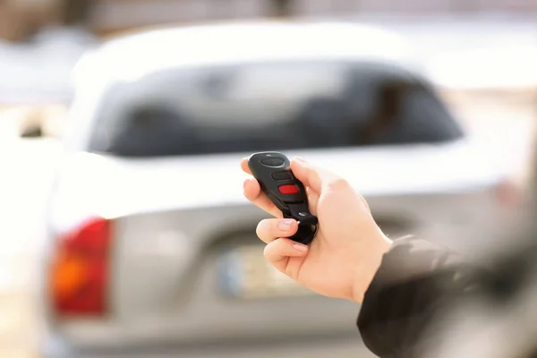 Mujer joven usando alarma de coche al aire libre — Foto de Stock