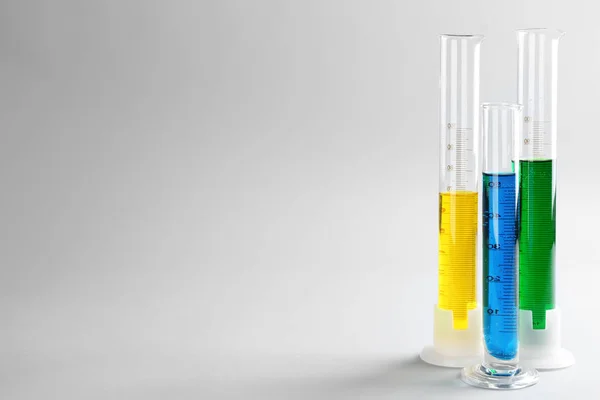Test tubes with colorful liquids on light background — Stock Photo, Image
