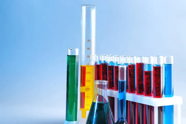 Cristalería química con diferentes líquidos sobre fondo de color — Foto de Stock