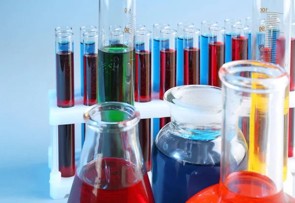 Vidros químicos com líquidos diferentes sobre fundo de cor — Fotografia de Stock