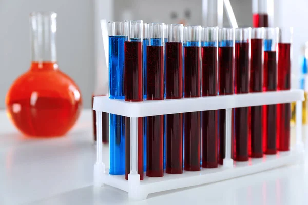 Тестові трубки з барвистими рідинами в тримачі на столі — стокове фото