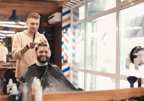 Barbier professionnel travaillant avec le client dans le salon de coiffure — Photo