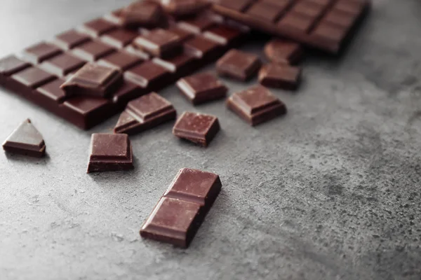 Sabroso chocolate negro sobre fondo gris — Foto de Stock