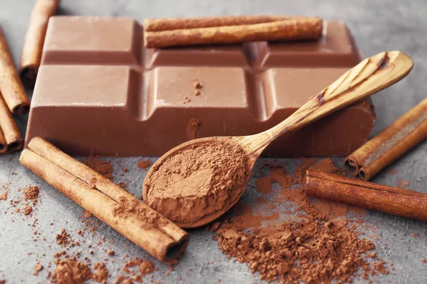 Tasty milk chocolate with cinnamon on table, closeup — Stock Photo, Image