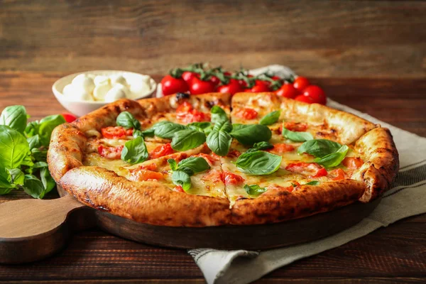 Board with delicious pizza Margherita on wooden table — Stock Photo, Image