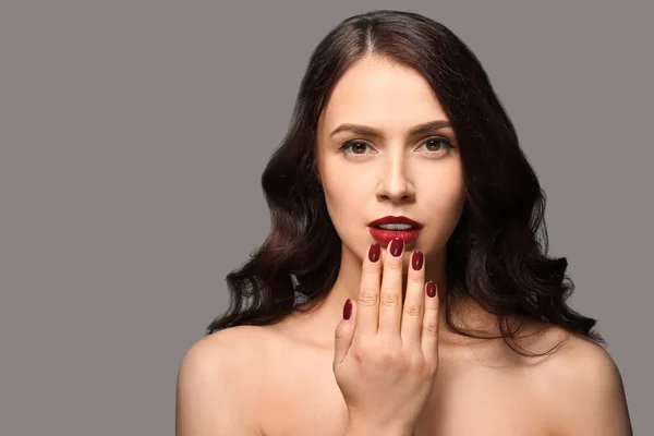 Beautiful young woman with professional manicure on grey background — Stock Photo, Image