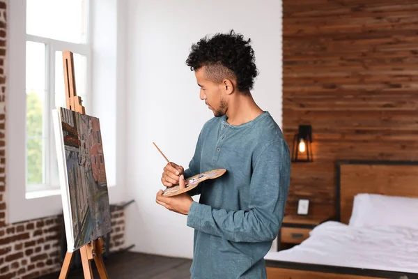 Молодой афроамериканец пишет картины дома — стоковое фото