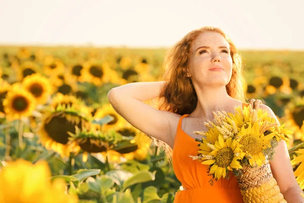 Beautiful redhead woman in sunflower field on sunny day — Stock Photo, Image