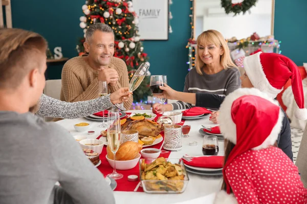 Glad familj som äter julmiddag hemma — Stockfoto